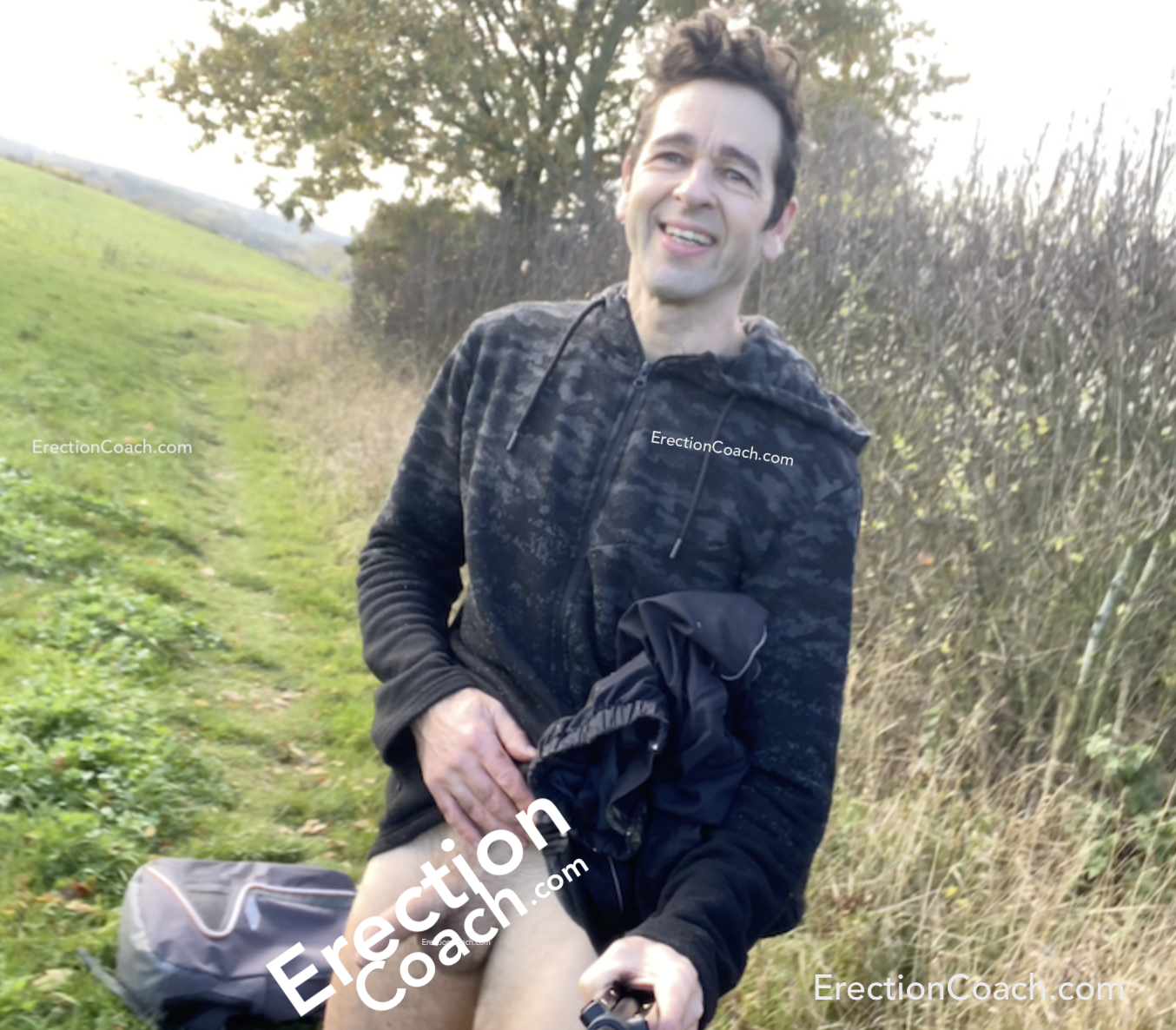 coach with pants down in a field - penis partially obscured with text